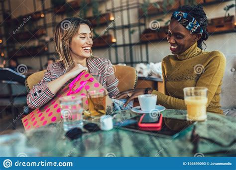 Female Friends Talking At A Coffee Shop After Shopping Stock Image