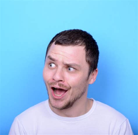Portrait Of Man With Funny Face Against Blue Background Stock Photo