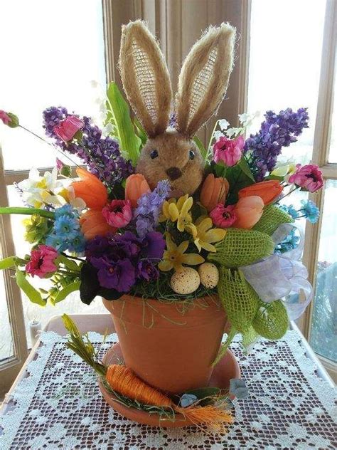 A Potted Plant With Flowers And A Stuffed Rabbit In It Sitting On A Table