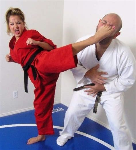 A Man And Woman In Karate Gear Standing On A Blue Mat With Their Hands Together