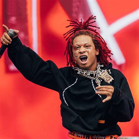 A Man With Dreadlocks On His Head Holding A Microphone And Pointing To