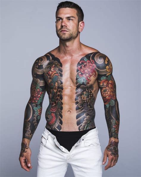 A Man With Many Tattoos On His Chest And Arms Is Posing For The Camera