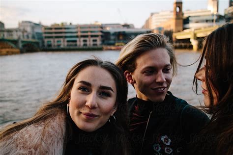 Cute Twenties Friends Tstanding On The Banks Of The Thames In London