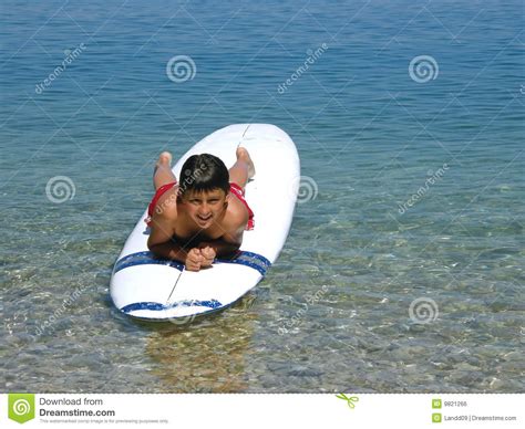 Menino Que Encontra Se Em Ressacas Na Praia Foto De Stock Imagem De