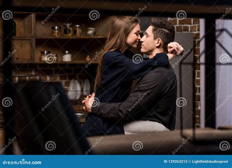 Girlfriend Sitting On Table In Kitchen And Going To Kiss Boyfriend Stock Image Image Of