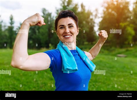 Smiling Senior Woman Flexing Muscles Outdoor In Park Elderly Female Showing Biceps Heathy Life