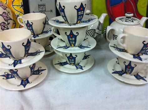 A Table Topped With Cups And Saucers Covered In Blue Designs On White