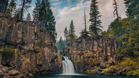 Landscape View Of Waterfall Pouring On River Between Rock Mountains