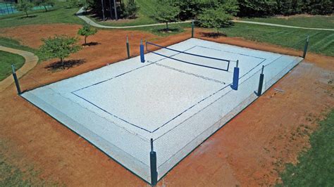Sand pits sit in the center of two raised gravel beds, backed by low walls. How To Construct A Volleyball Court