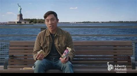 This Man Sitting On A Bench And Eating By The Statue Of Liberty Is