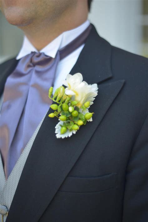 White Freesia Boutonniere With Green Hypericum Berries And Dusty Miller