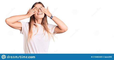 Beautiful Caucasian Woman Wearing Casual White Tshirt Covering Eyes With Hands Smiling Cheerful