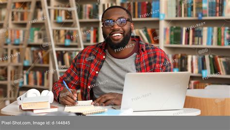 African American Student Preparing For Exam In Library Stock