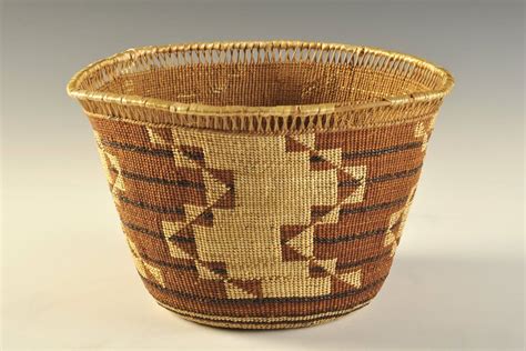 A Woven Basket With Brown And Tan Designs On The Inside Sitting On A