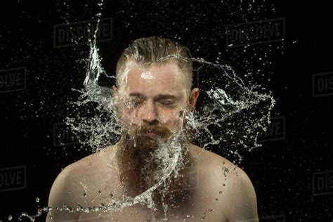 Water Splashing On Shirtless Man S Face Against Black Background