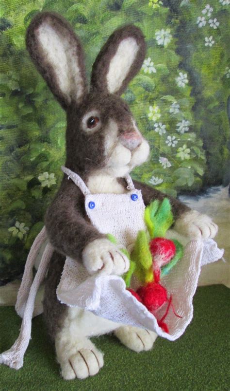 A Stuffed Rabbit Holding A Carrot In Front Of A Wall With Green Grass