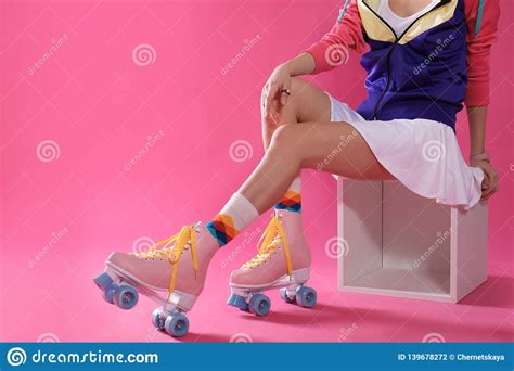 Young Woman With Retro Roller Skates On Color Background Closeup