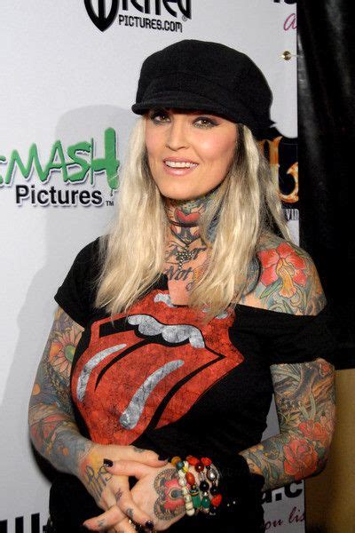 A Woman With Tattoos And Piercings On Her Chest Posing For The Camera