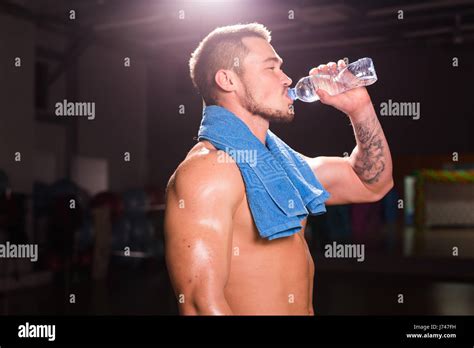 Young Caucasian Bodybuilder In The Gym Drinking A Bottle Water Stock