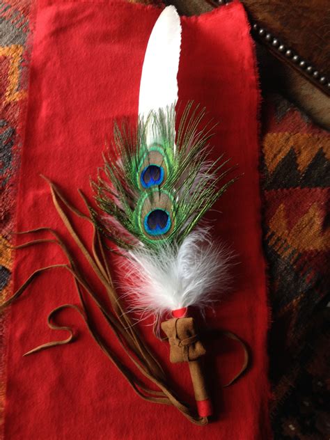 Two Feathers Are Sitting On Top Of A Red Cloth