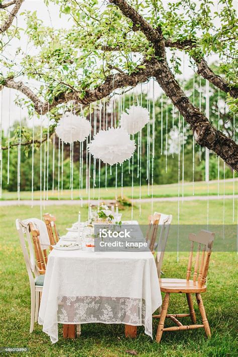 Garden Party Arrangement With Decorations Hanging From Tree Stock Photo