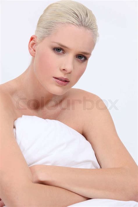 Blond Kvinde Nøgen Sidder På Sengen Med En Neutral Ansigt Udtryk Stock Foto Colourbox