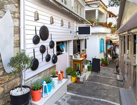Vista da rua estreita da ilha de skopelos grécia com menus de tabernas