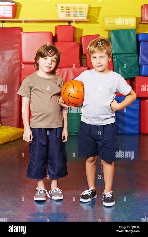 Two Boys Standing With Basketball In Gym Of An Elementary School Stock