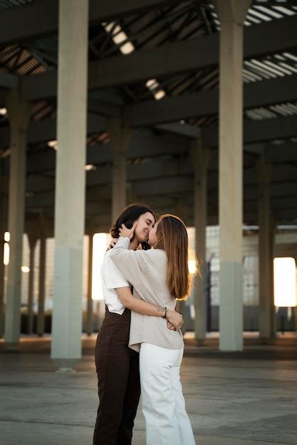 Adorable pareja de lesbianas besándose al aire libre Foto Gratis