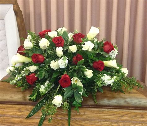 Assorted pink flowers in a casket cover. Casket spray of red and white roses along with calla ...