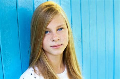 Portrait Of Pretty Teen Girl On Blue Wooden Wall Background Stock Image