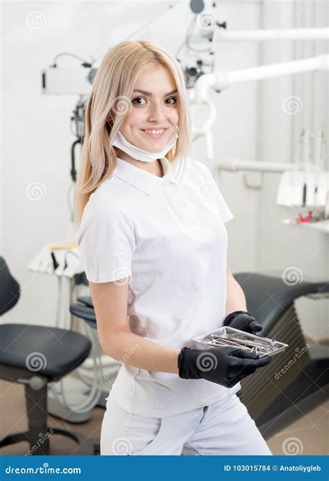 Portrait Of Young Attractive Female Dentist Holding Dental Tool At The