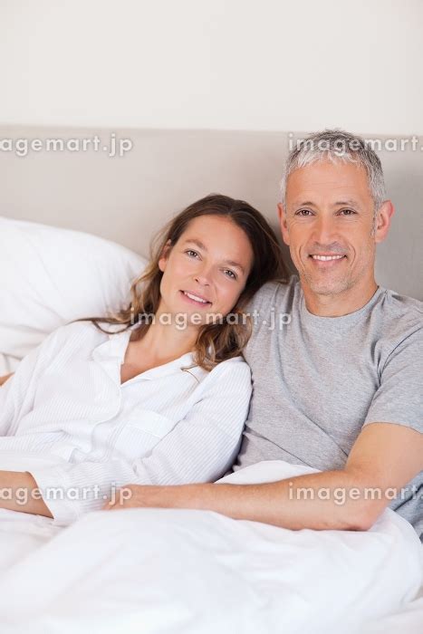 Portrait Of A Couple Lying On A Bed While Looking At The Cameraの写真素材 31584021 イメージマート