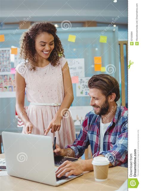 Graphic Designers Interacting While Using Laptop And Graphic Tablet
