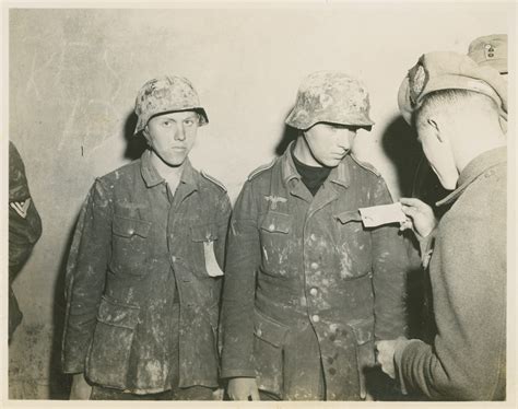 An Allied Soldier Examines Pow Tags On Two Young German Soldiers In