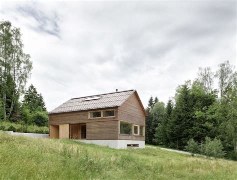 A Small Wooden House Sitting On Top Of A Lush Green Hillside Next To