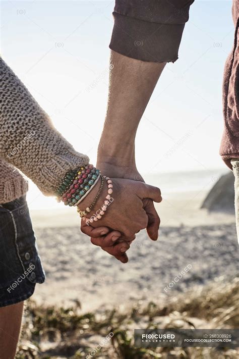 Close Up Of Couple Holding Hands At Sunset On Beach — Nature Vacation