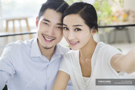 Chinese Couple Sitting Cheek To Cheek In Cafe — Cups Indoors Stock