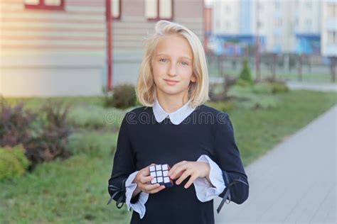 La Belle Et Intelligente Fille Blonde Denfant Résout Un Puzzle De Cube