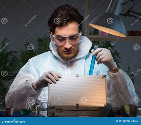 Forensic Investigator Working In Lab Looking For Evidence Stock Image