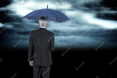Premium Photo Businessman Holding Umbrella Against Stormy Dark Sky
