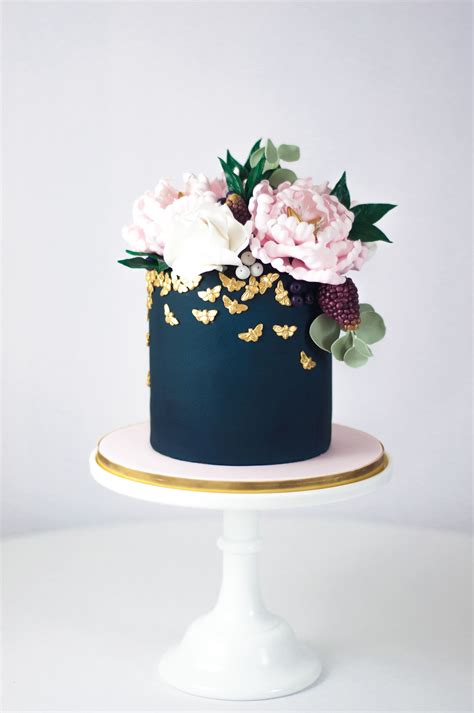 The bride holding blush bouquet, the girls in ice blue bridesmaid dresses, the wedding cake with blush blooms, the table featured blue water glasses, and centerpieces filled with blush and ivory blooms and fresh greenery, and plenty of candles. Navy blue wedding cake with blush sugar flowers | Juniper ...