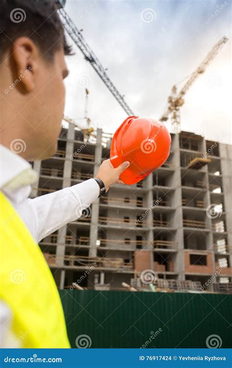 Rear View Image Of Construction Engineer Pointing At Building Si Stock