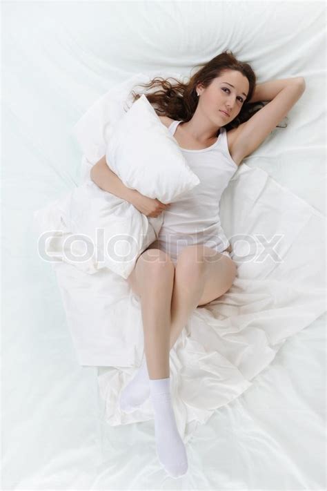 Junge schöne Frau auf dem Bett liegend Stockfoto Colourbox