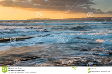 Rocky Seashore Seascape With Wavy Ocean During Sunset Stock Image