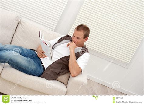 Smiling man lying and relaxing on the couch at home in the living room. Man Relaxing On The Couch Royalty Free Stock Photography ...