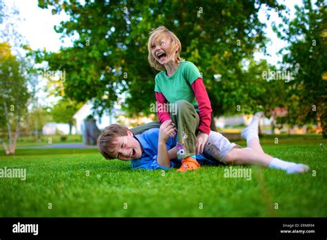 A Boy And Girl Wrestling On The Grass Picton Ontario Canada Stock
