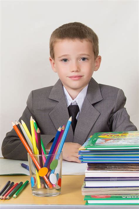 Free Photo Schoolboy At The Desk Sitting Books Pencils Bright