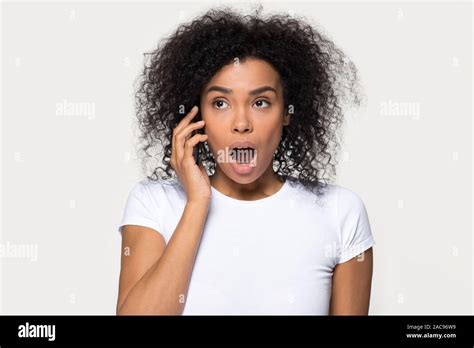 Shocked African American Woman Talking On Phone Hearing Unexpected