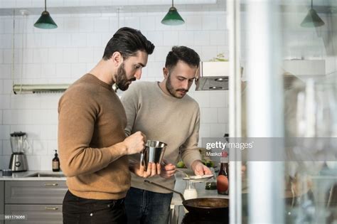 Gay Couple Preparing Food In Kitchen At Home Photo Getty Images